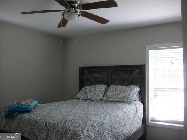 bedroom with ceiling fan and multiple windows