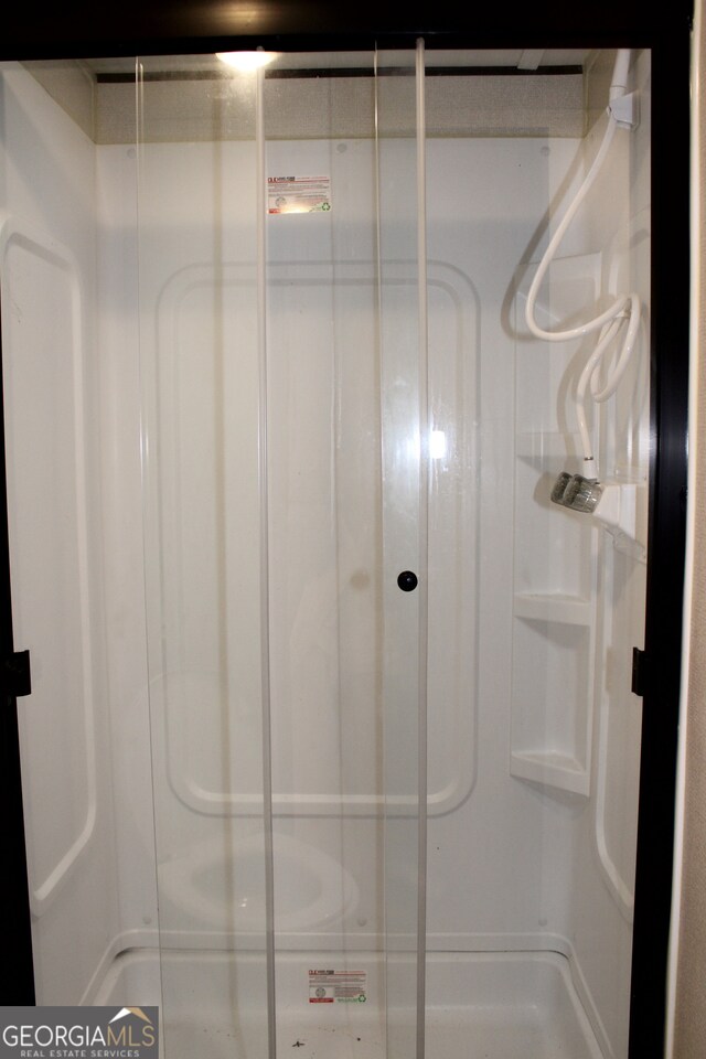 bathroom featuring a shower with door