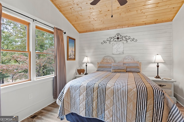 bedroom with hardwood / wood-style floors, lofted ceiling, multiple windows, and wooden ceiling