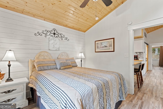 bedroom featuring wood walls, light hardwood / wood-style floors, wooden ceiling, and ceiling fan