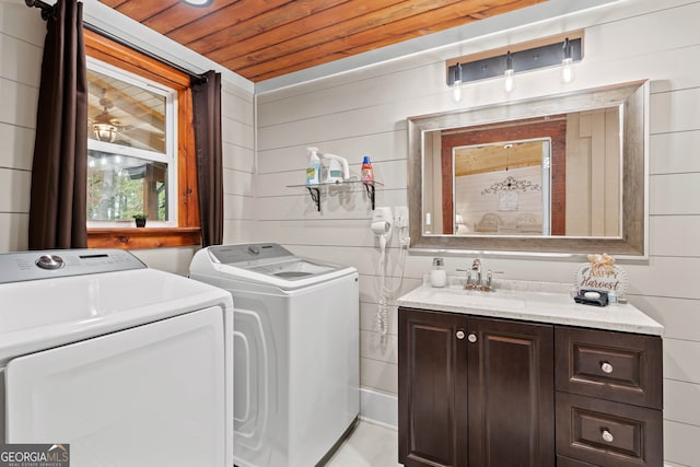 washroom featuring wood walls, sink, independent washer and dryer, and wooden ceiling