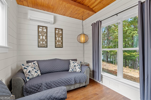 interior space with wood walls, wooden ceiling, a wall unit AC, beam ceiling, and hardwood / wood-style floors