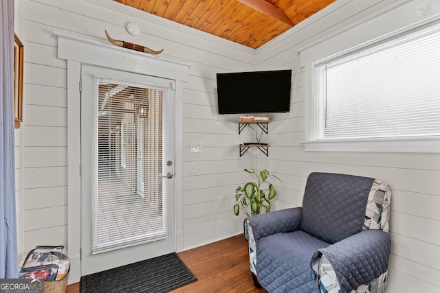 living area with a wealth of natural light, wood walls, wood ceiling, and dark hardwood / wood-style flooring