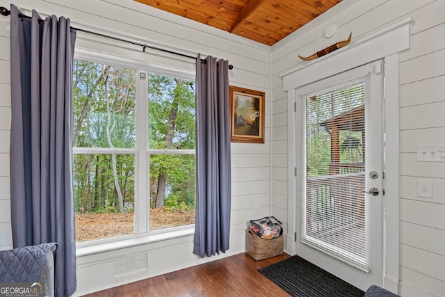 entryway with dark wood-type flooring, wood walls, and wood ceiling