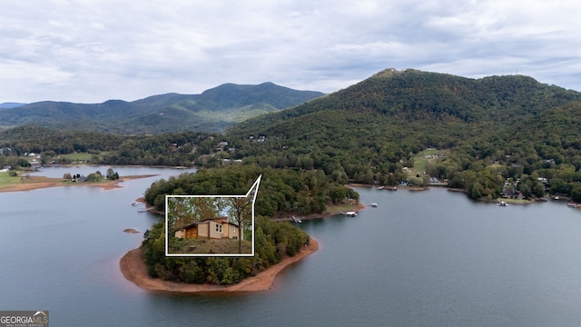 drone / aerial view featuring a water and mountain view