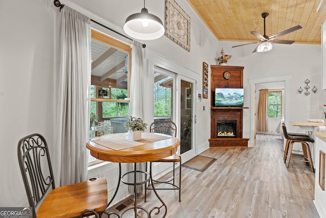 dining room with ornamental molding, ceiling fan, wood ceiling, light wood-type flooring, and vaulted ceiling