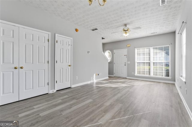 unfurnished living room featuring ceiling fan, a textured ceiling, and light wood-type flooring