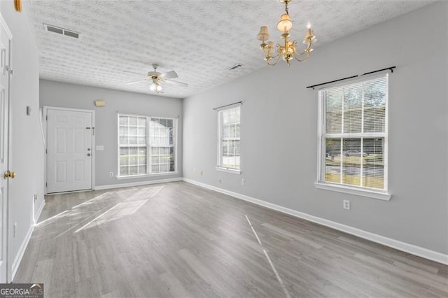 interior space featuring hardwood / wood-style floors, a textured ceiling, and ceiling fan with notable chandelier