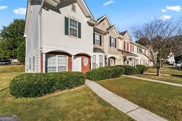 townhome / multi-family property featuring a front yard