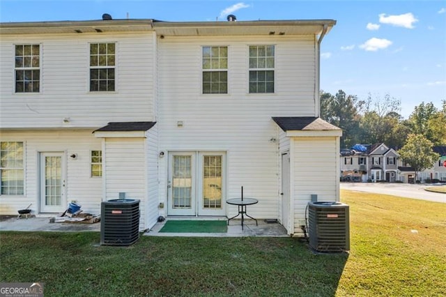 rear view of house featuring a patio, a lawn, and central AC unit