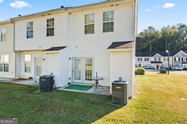 back of house featuring central AC and a yard