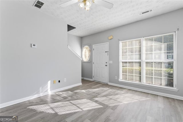 entryway with light hardwood / wood-style floors, a textured ceiling, and ceiling fan