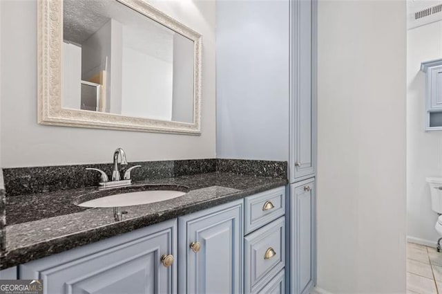 bathroom featuring vanity, toilet, and tile patterned flooring