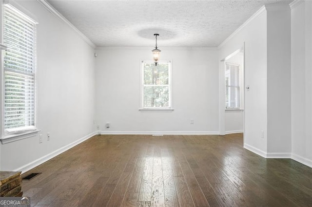 empty room featuring a textured ceiling, a healthy amount of sunlight, and dark hardwood / wood-style flooring