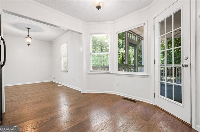 empty room featuring crown molding, a textured ceiling, and dark hardwood / wood-style flooring