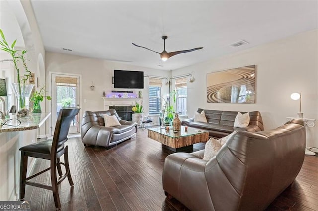 living room featuring ceiling fan and dark hardwood / wood-style flooring