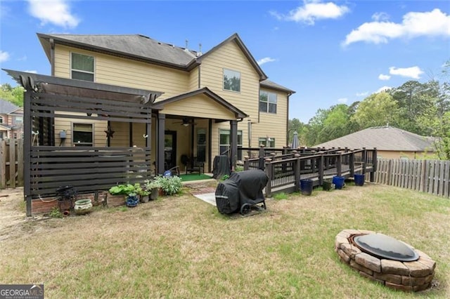 rear view of house with an outdoor fire pit, a lawn, and a pergola