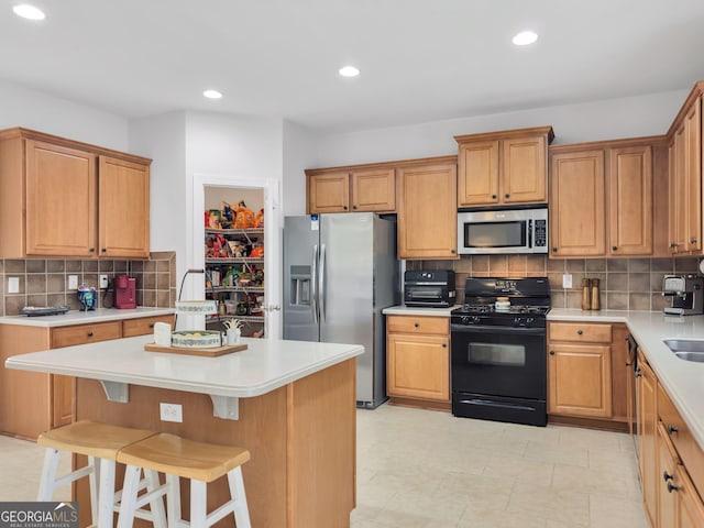 kitchen featuring tasteful backsplash, a center island, sink, a kitchen breakfast bar, and stainless steel appliances