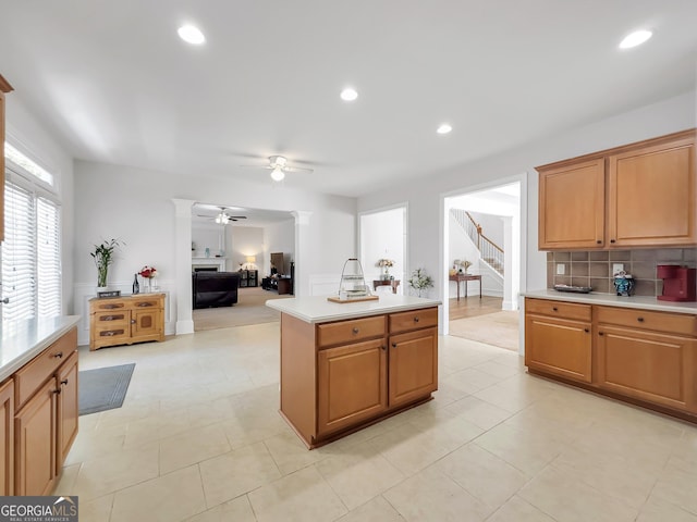 kitchen with ceiling fan, light tile patterned floors, tasteful backsplash, and a center island