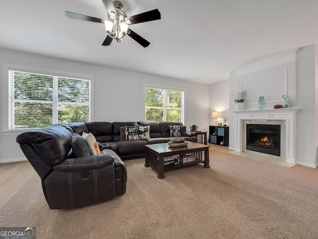 carpeted living room with a fireplace and ceiling fan