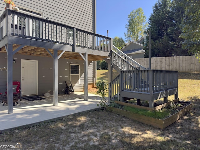 back of house with a wooden deck and a patio