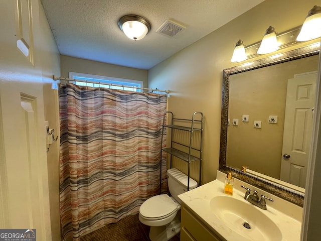 bathroom featuring toilet, a textured ceiling, walk in shower, and vanity