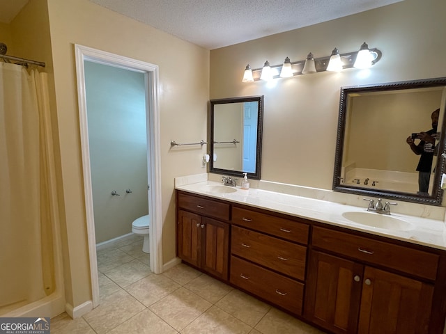 bathroom featuring a textured ceiling, a shower with shower curtain, toilet, vanity, and tile patterned flooring