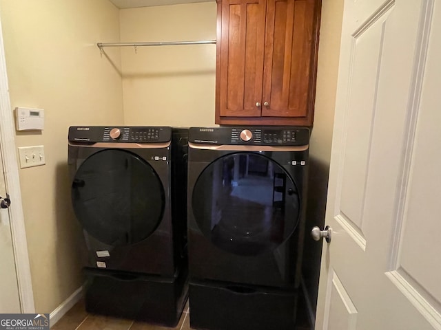 clothes washing area with tile patterned floors, cabinets, and washer and clothes dryer