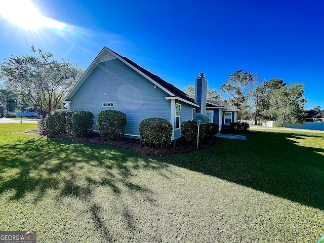 view of side of home with a yard