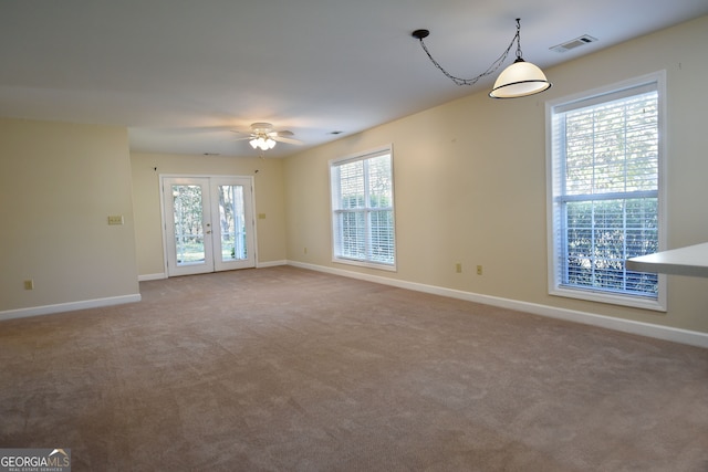 unfurnished room featuring carpet, a healthy amount of sunlight, and ceiling fan