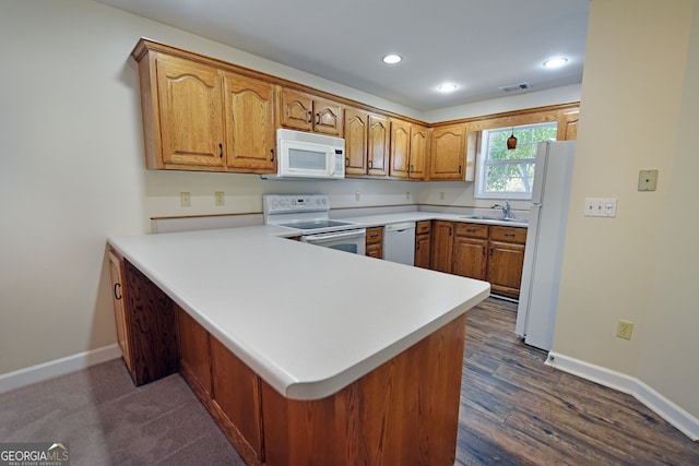 kitchen with kitchen peninsula, sink, dark wood-type flooring, and white appliances