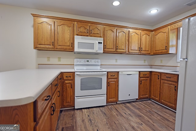 kitchen with kitchen peninsula, white appliances, and dark hardwood / wood-style flooring