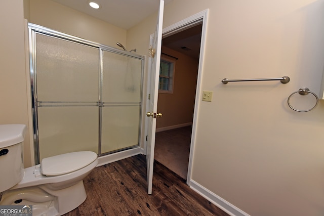 bathroom with toilet, a shower with shower door, and wood-type flooring