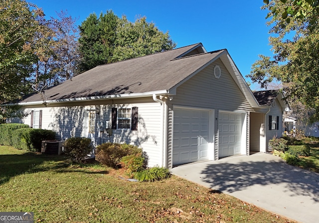 view of front of property featuring a front yard, a garage, and cooling unit