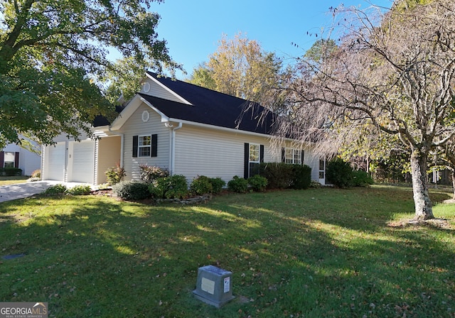 view of side of home featuring a yard and a garage