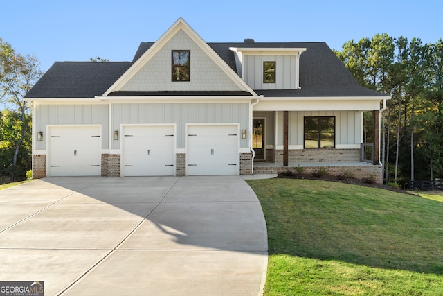 view of front facade featuring covered porch, a front lawn, and a garage