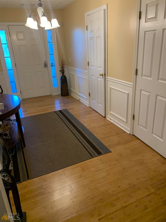 foyer entrance featuring a chandelier and light wood-type flooring