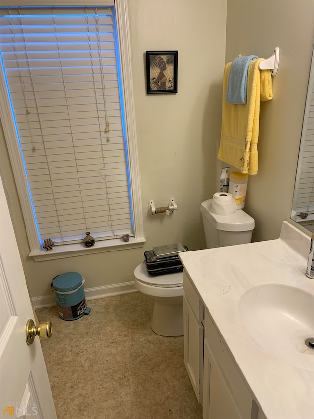 bathroom featuring toilet, walk in shower, and vanity