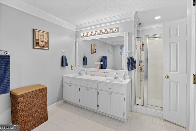 bathroom with a textured ceiling, ornamental molding, a shower with shower door, vanity, and tile patterned flooring