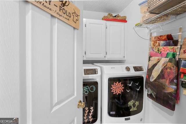 laundry room with washer and dryer, a textured ceiling, and cabinets