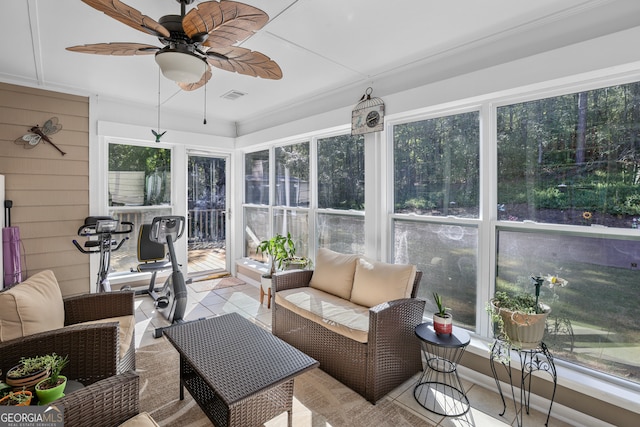 sunroom / solarium featuring a healthy amount of sunlight and ceiling fan