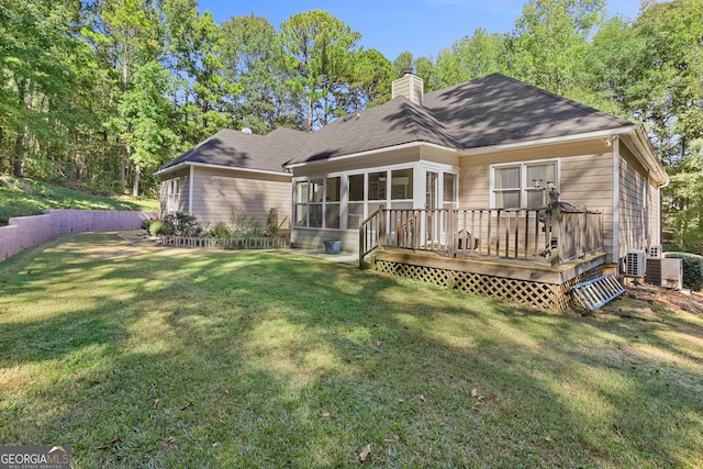 back of property with a yard, a sunroom, and a deck