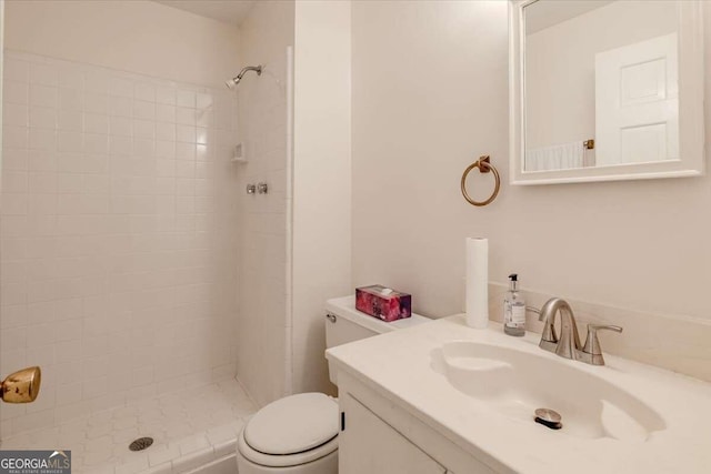 bathroom featuring vanity, toilet, and tiled shower