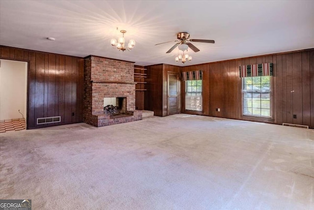 unfurnished living room featuring wooden walls and light carpet