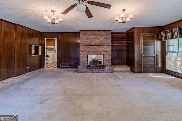 unfurnished living room with crown molding, wood walls, carpet floors, and a fireplace