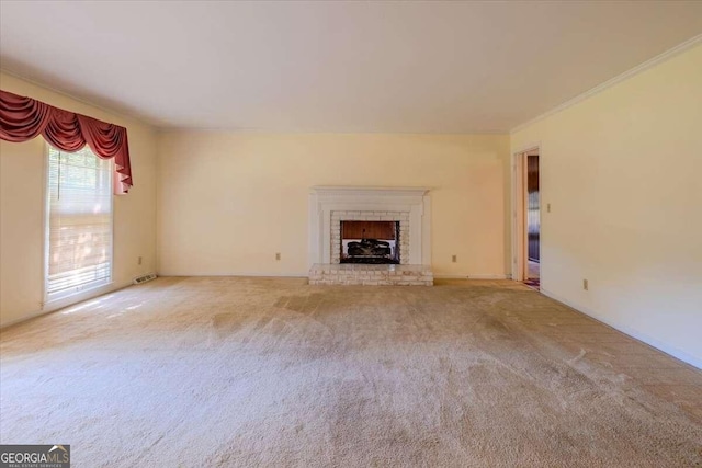 unfurnished living room with ornamental molding, carpet floors, and a brick fireplace