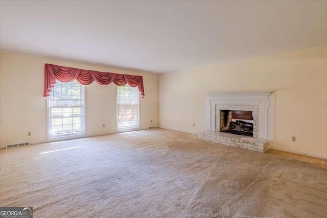 unfurnished living room featuring carpet and a brick fireplace