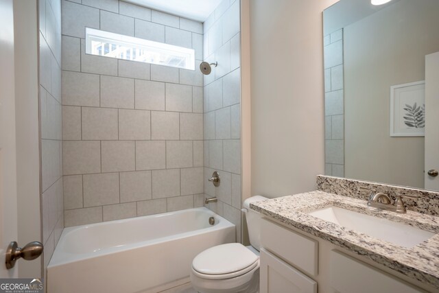 full bathroom with toilet, tiled shower / bath, and vanity