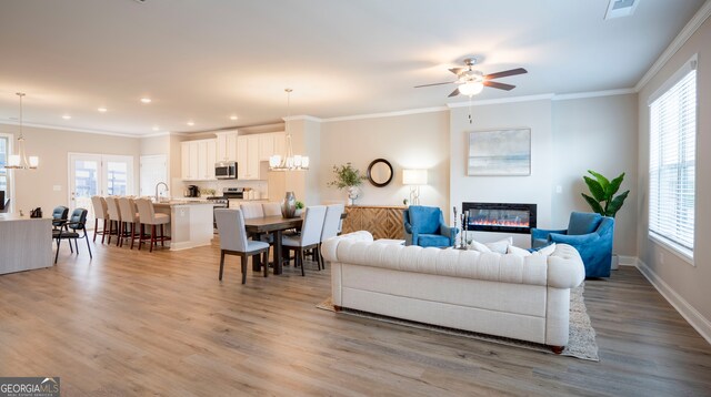 living room featuring hardwood / wood-style flooring, ceiling fan with notable chandelier, and plenty of natural light