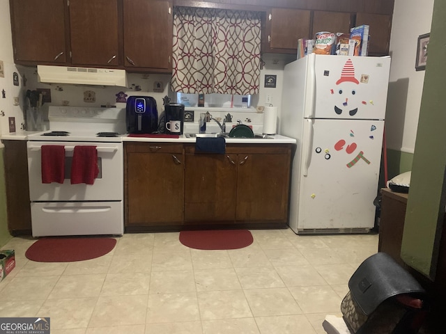 kitchen with dark brown cabinets, white appliances, and sink